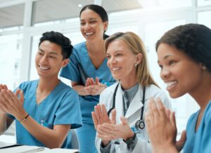 Shot of a group of doctors clapping hands in a meeting at work